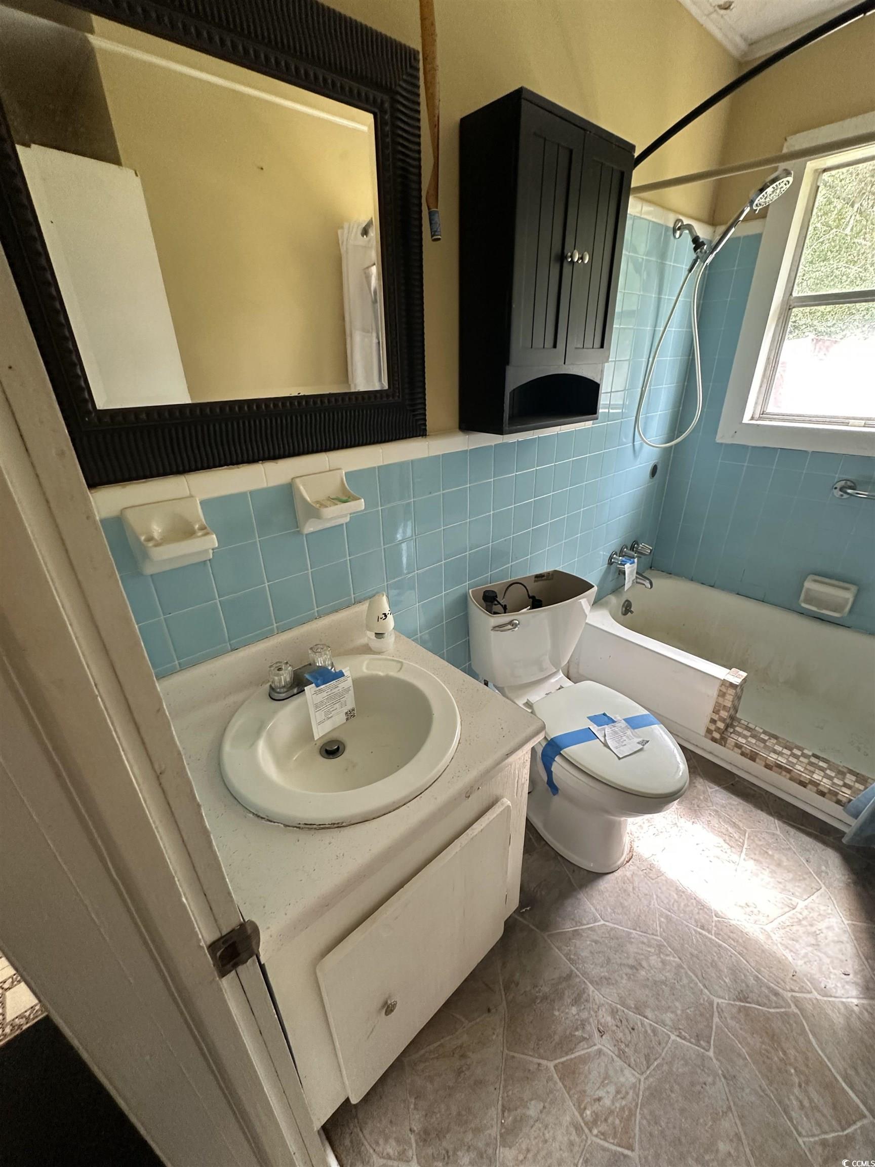 11185 Old Pee Dee Road Hemingway, SC 29554 - Photo 14 of 15 Full bathroom with tiled shower / bath combo, vanity, and tile walls