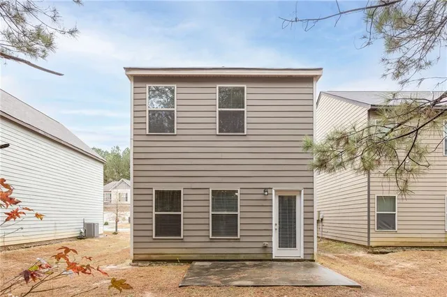 a view of a white house with a large tree