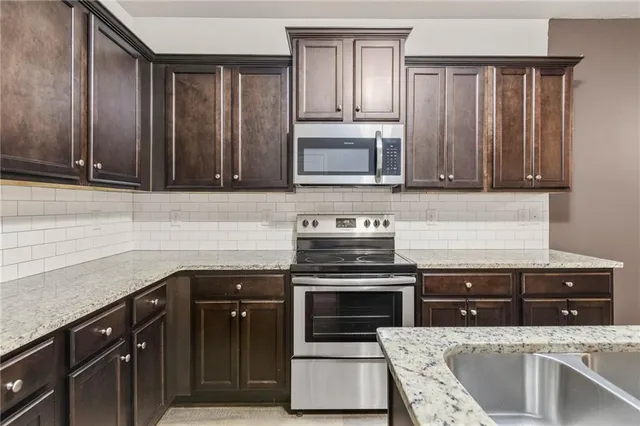 a kitchen with granite countertop cabinets stainless steel appliances and wooden cabinets