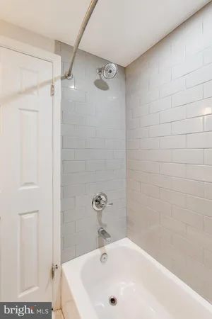 a white bath tub sitting next to a white sink and a shower