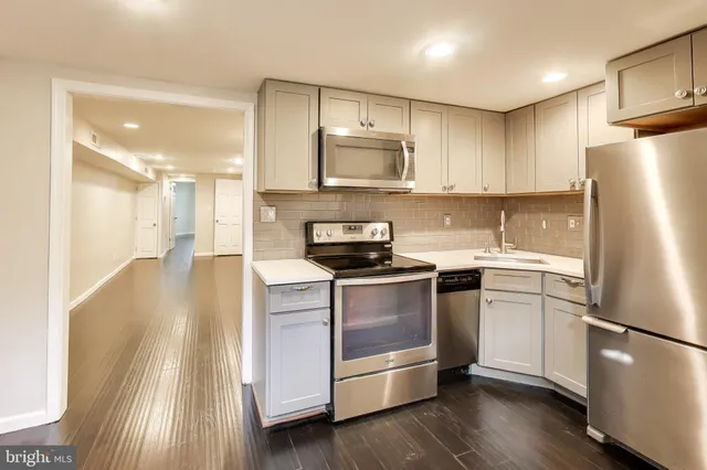 a kitchen with stainless steel appliances a refrigerator sink and microwave