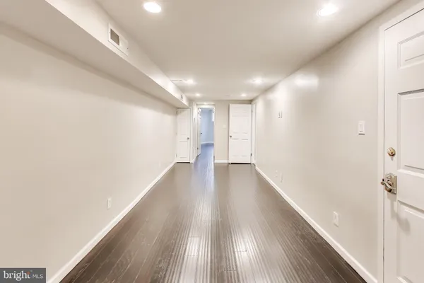 a view of a hallway with wooden floor
