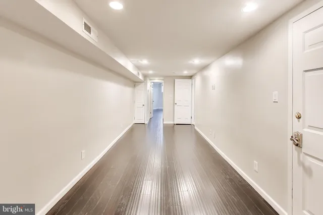 a view of a hallway with wooden floor