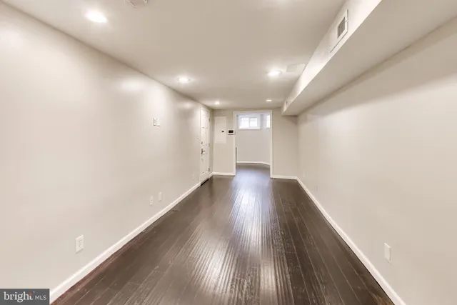 a view of empty room with wooden floor