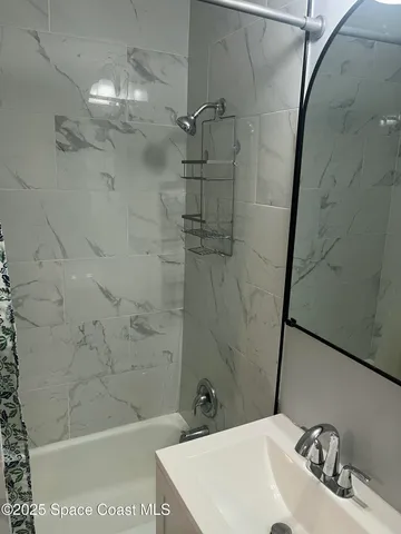 a bathroom with a sink a mirror and shower