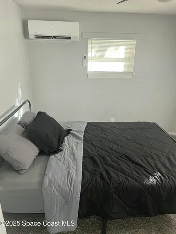 a bed sitting in a bedroom next to a window