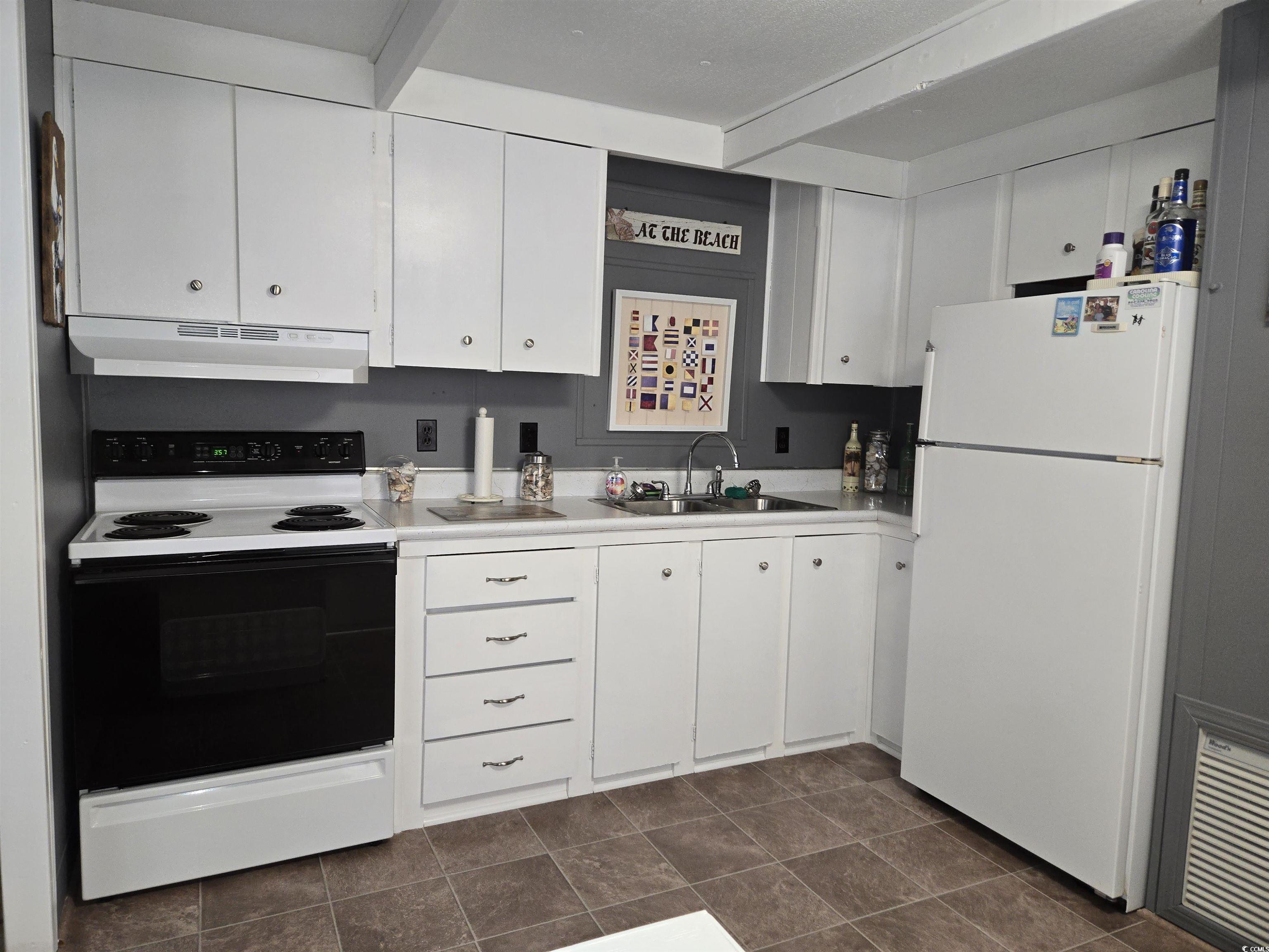 425 Delton Drive Murrells Inlet, SC 29576 - Photo 12 of 34 Kitchen featuring freestanding refrigerator, a sink, white cabinets, electric stove, and under cabinet range hood