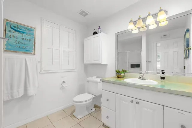 a bathroom with a granite countertop sink a toilet and mirror