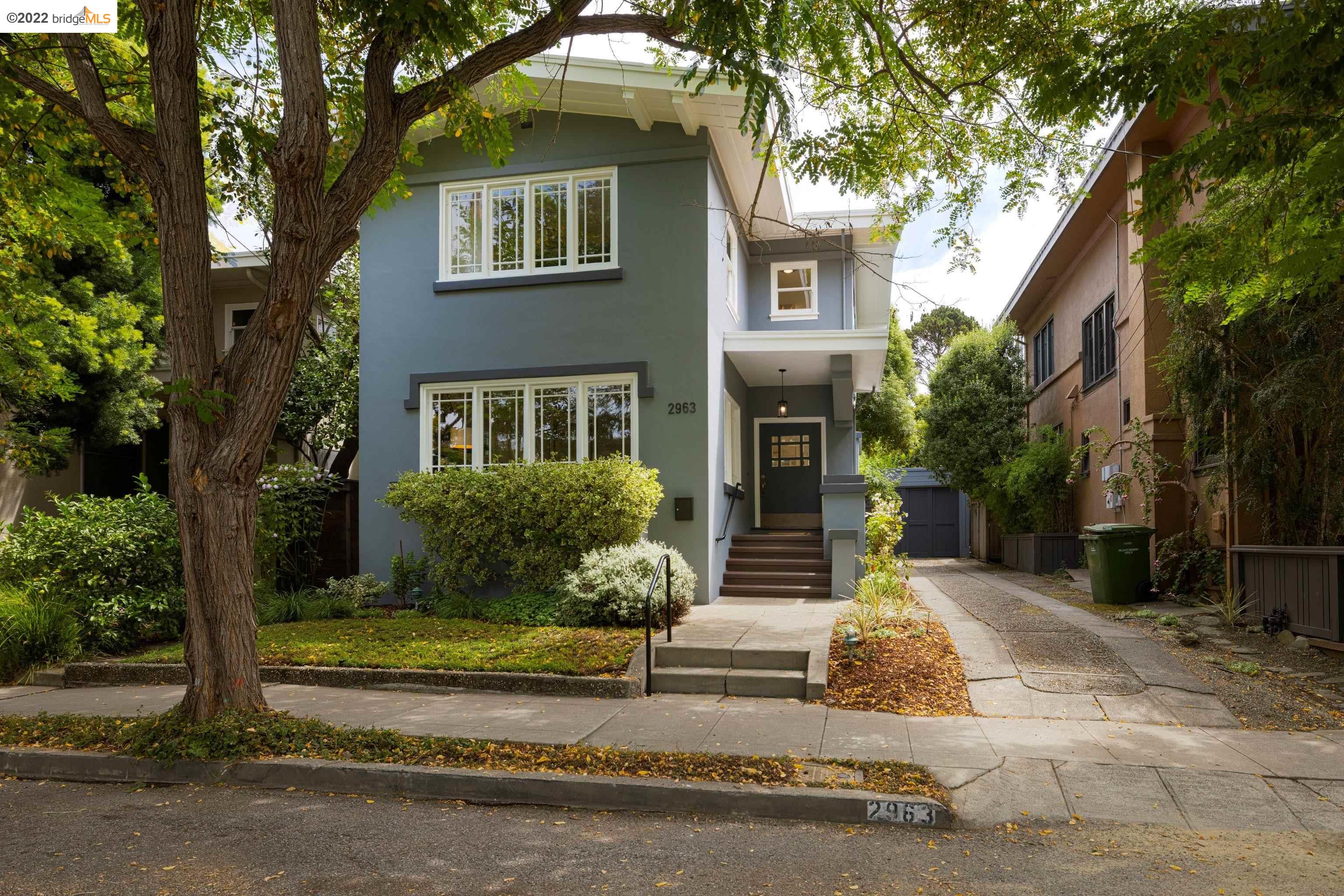 2963 Magnolia Street Berkeley, CA 94705 - Photo 1 of 1 a view of a white house with a large windows and a yard with plants and large trees