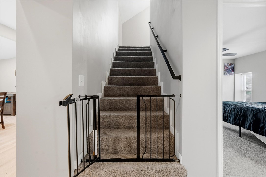 2950 Fairfield Pike Springfield, OH 45502 - Photo 27 of 48 This carpeted staircase connects levels, featuring a sleek black handrail and a child safety gate.