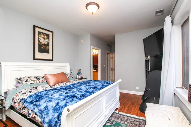 a bedroom with bed and wooden floor