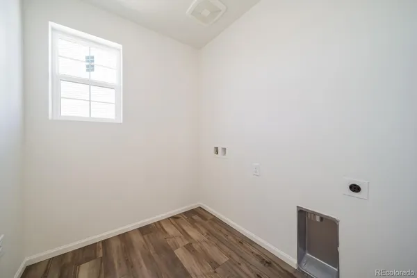 a view of a small space with wooden floor and a window