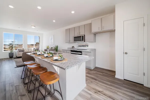 a kitchen that has a lot of cabinets a sink and appliances in it