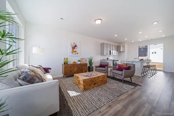 a living room with furniture and a wooden floor