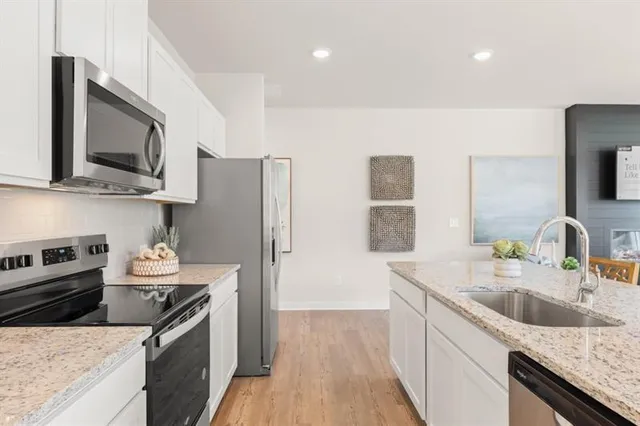 a kitchen with stainless steel appliances granite countertop a sink stove and refrigerator