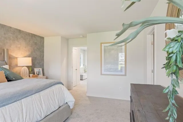 a bedroom with a bed and a potted plant