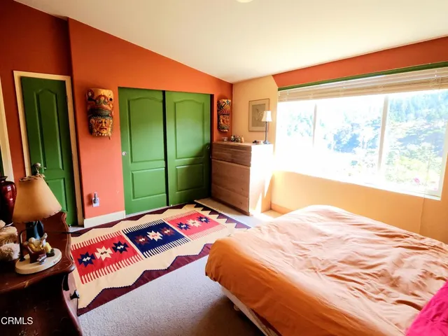 a bedroom with a bed window and dresser