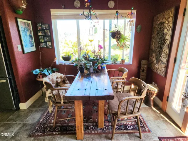 a view of a dining room with furniture a rug and wooden floor