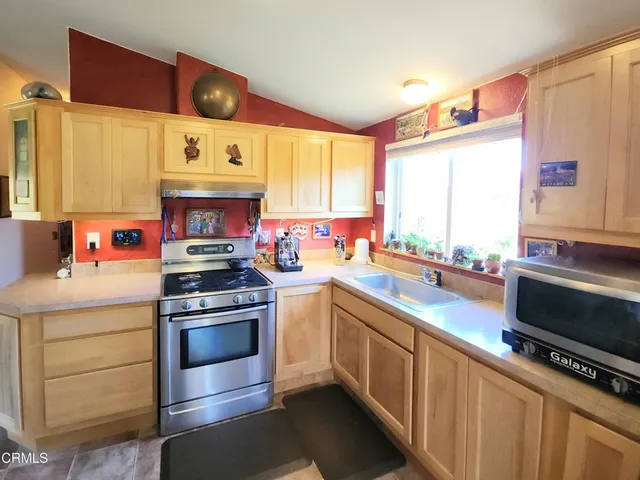 a kitchen with stainless steel appliances a stove a sink and a microwave