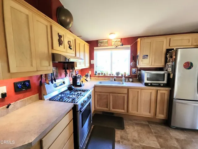 a kitchen with stainless steel appliances a stove a sink and a refrigerator