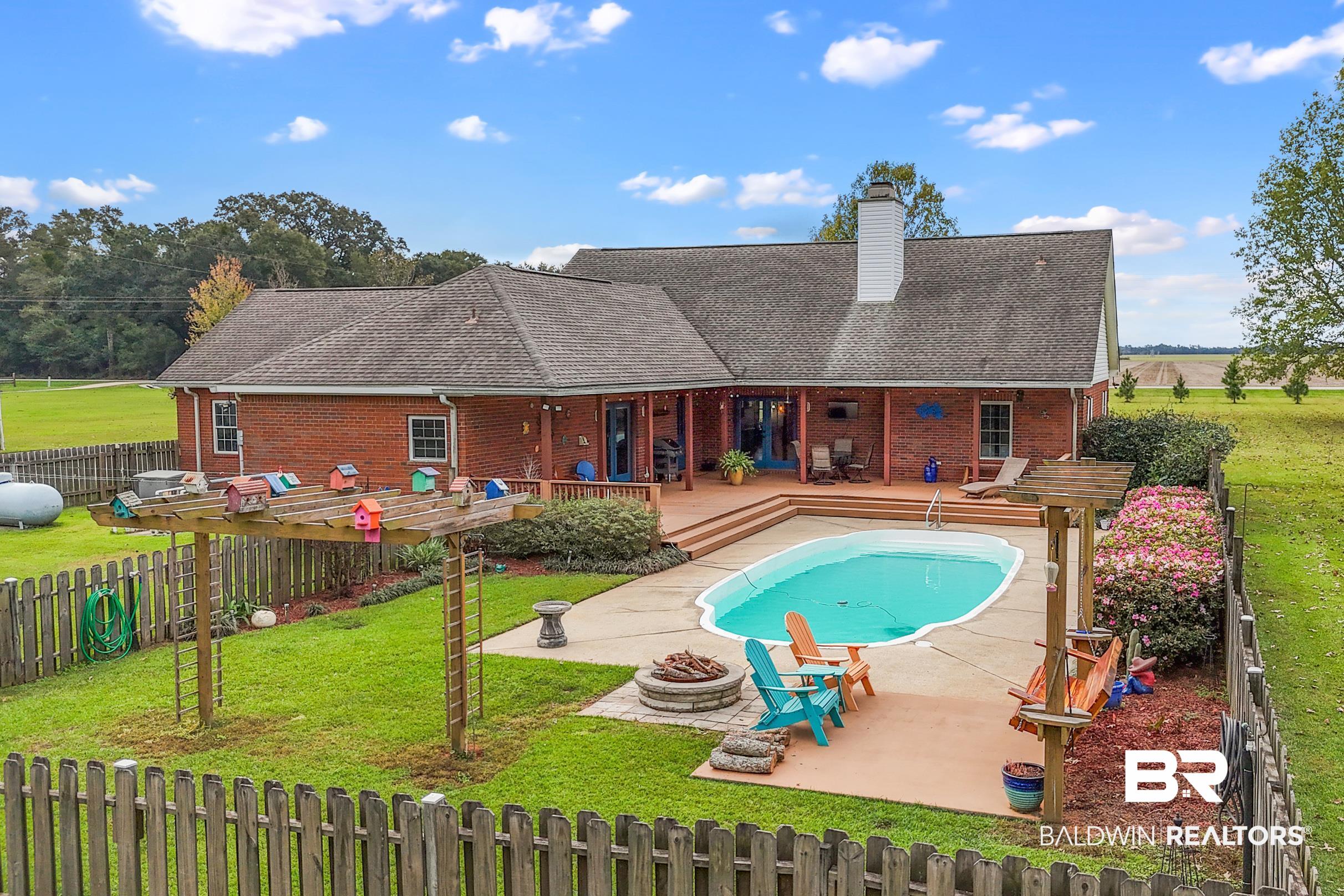 13871 Underwood Road Summerdale, AL 36580 - Photo 23 of 33 View of pool featuring an outdoor fire pit, a lawn, and a deck