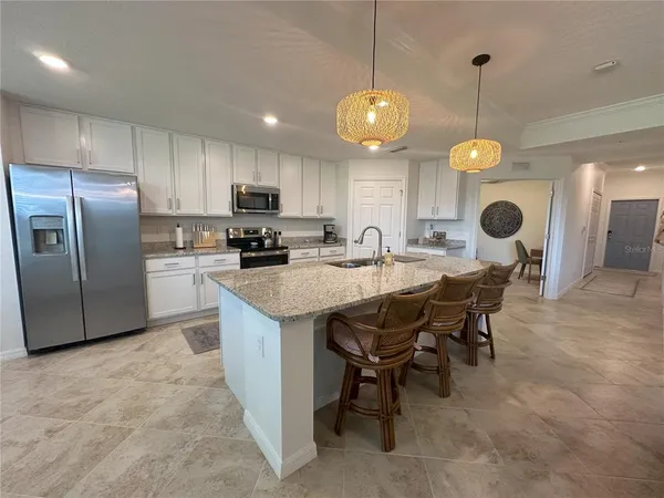 a kitchen with stainless steel appliances granite countertop a sink refrigerator and cabinets