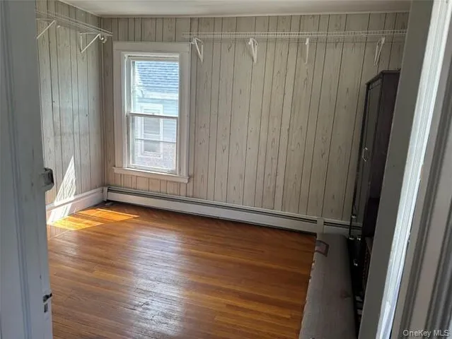 an empty room with wooden floor and a window