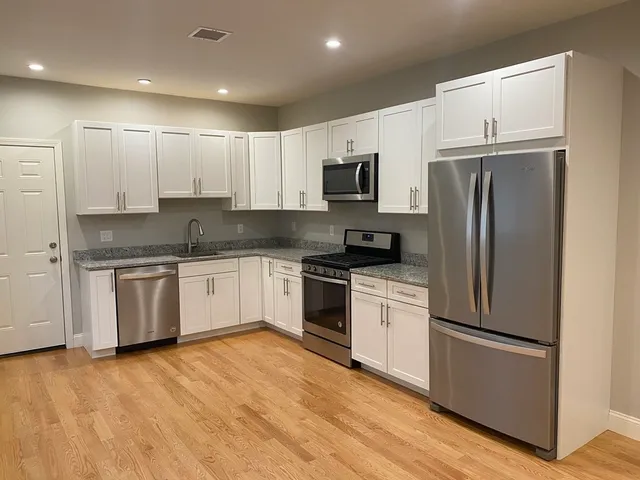 a kitchen with a refrigerator sink and cabinets