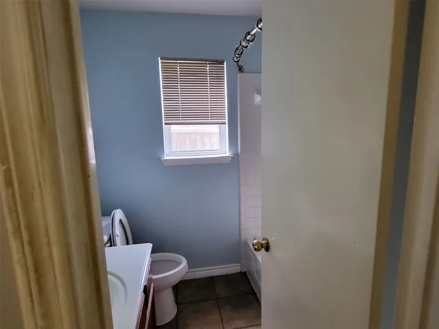 a white toilet sitting next to a window