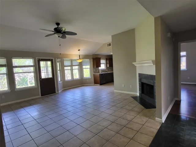 a view of an empty room with a fireplace and a window