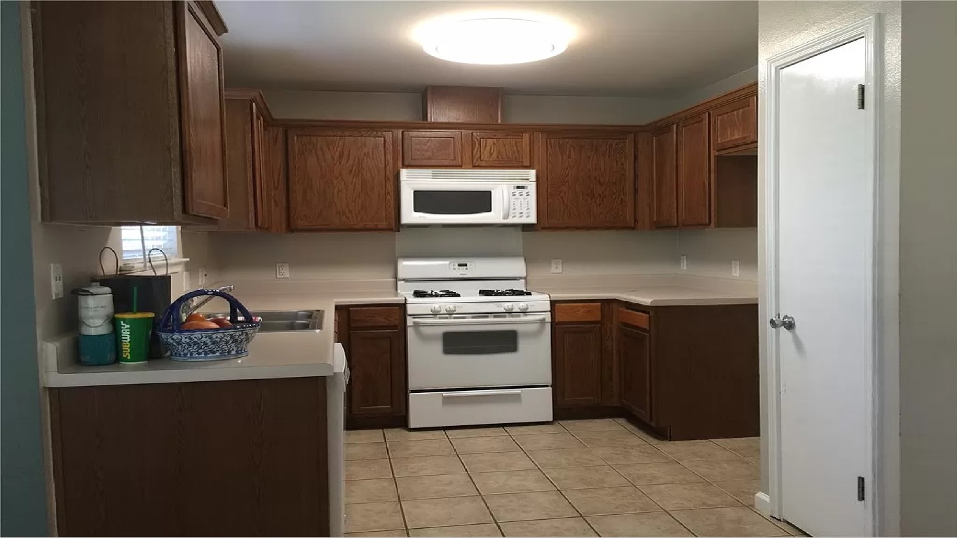 512 Maplecreek Drive Leander, TX 78641 - Photo 5 of 13 a kitchen with a stove and a microwave