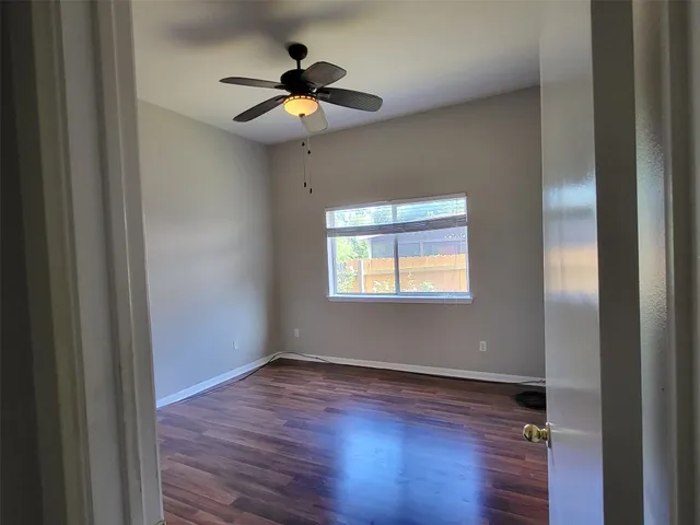 a view of an empty room with wooden floor