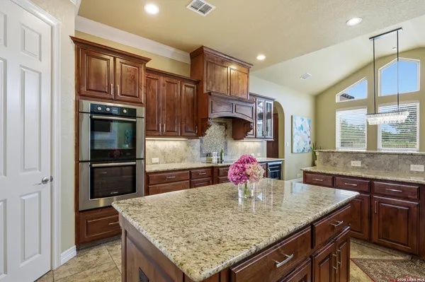 a kitchen with stainless steel appliances granite countertop a sink refrigerator and cabinets