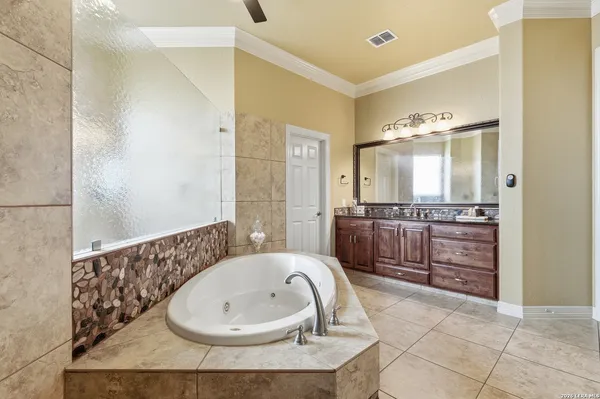 a bathroom with a granite countertop sink a mirror and a bathtub
