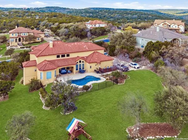 an aerial view of residential houses with outdoor space and trees
