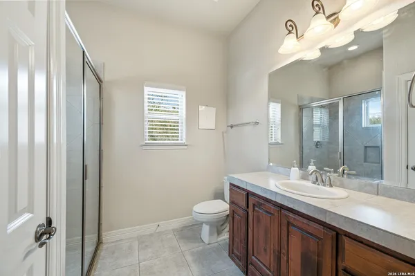 a bathroom with a granite countertop sink a toilet and a mirror