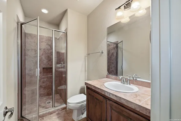 a bathroom with a granite countertop sink toilet and shower