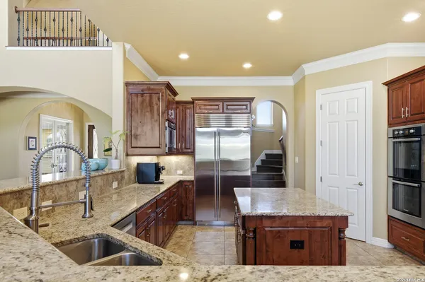 a kitchen with stainless steel appliances kitchen island granite countertop a refrigerator and a stove