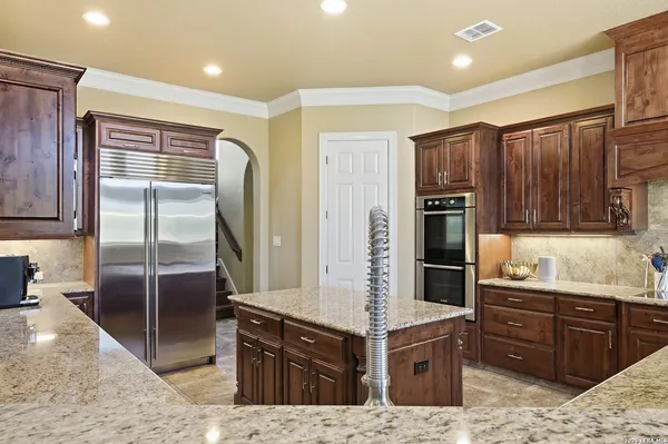a kitchen with stainless steel appliances kitchen island granite countertop a refrigerator and stove