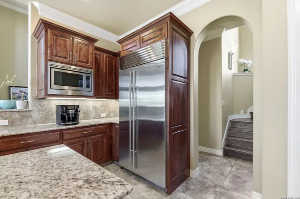a kitchen with granite countertop a refrigerator and a sink