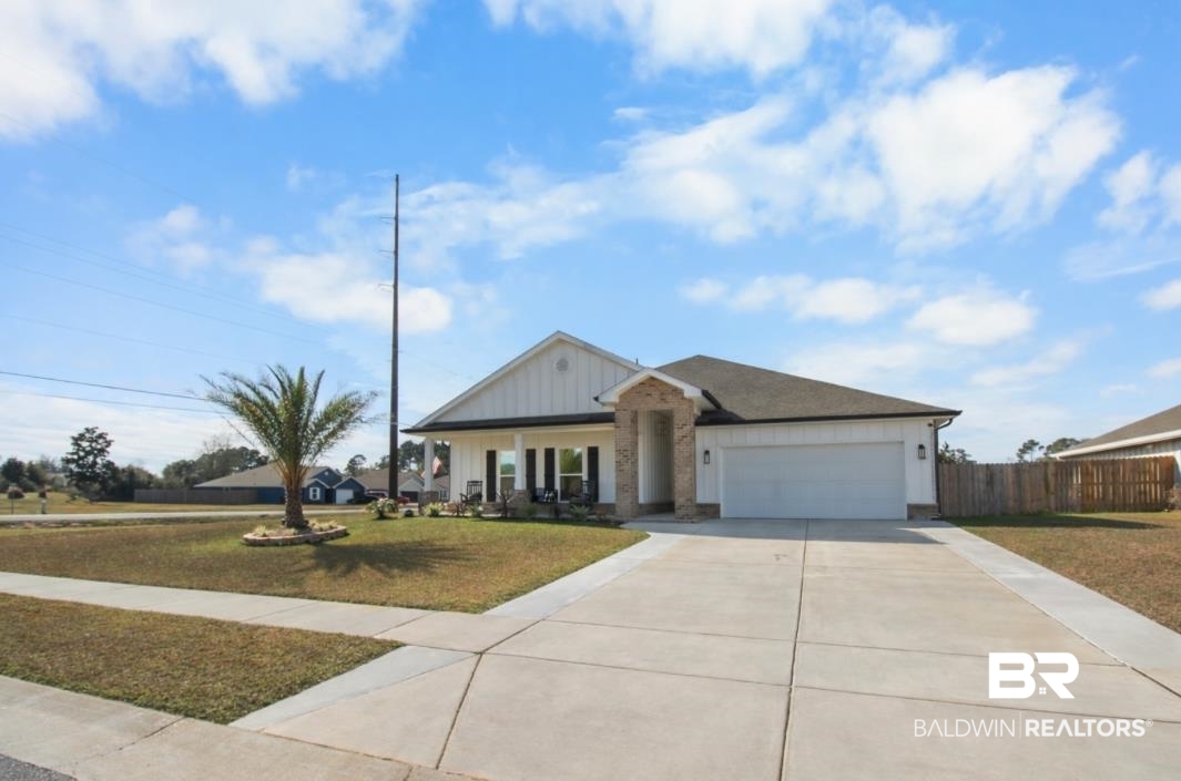 12523 Pheasant Run Elberta, AL 36530 - Photo 43 of 43 View of front facade with board and batten siding, covered porch, concrete driveway, and a garage