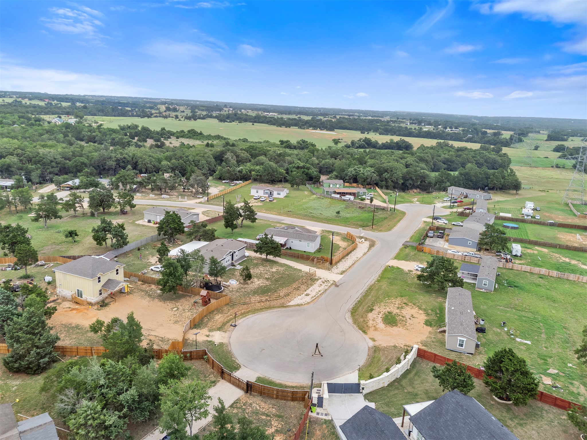 123 Zacate Street Elgin, TX 78621 - Photo 27 of 33 Aerial perspective showcasing a residential cul-de-sac with surrounding green spaces and mature trees