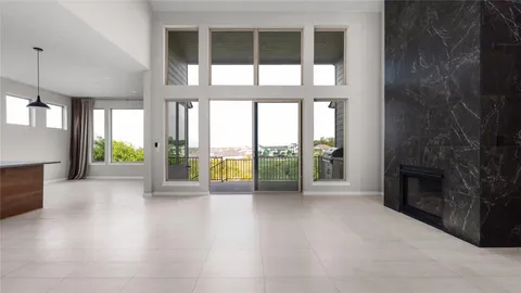 a view of an empty room with a fireplace and a floor to ceiling window