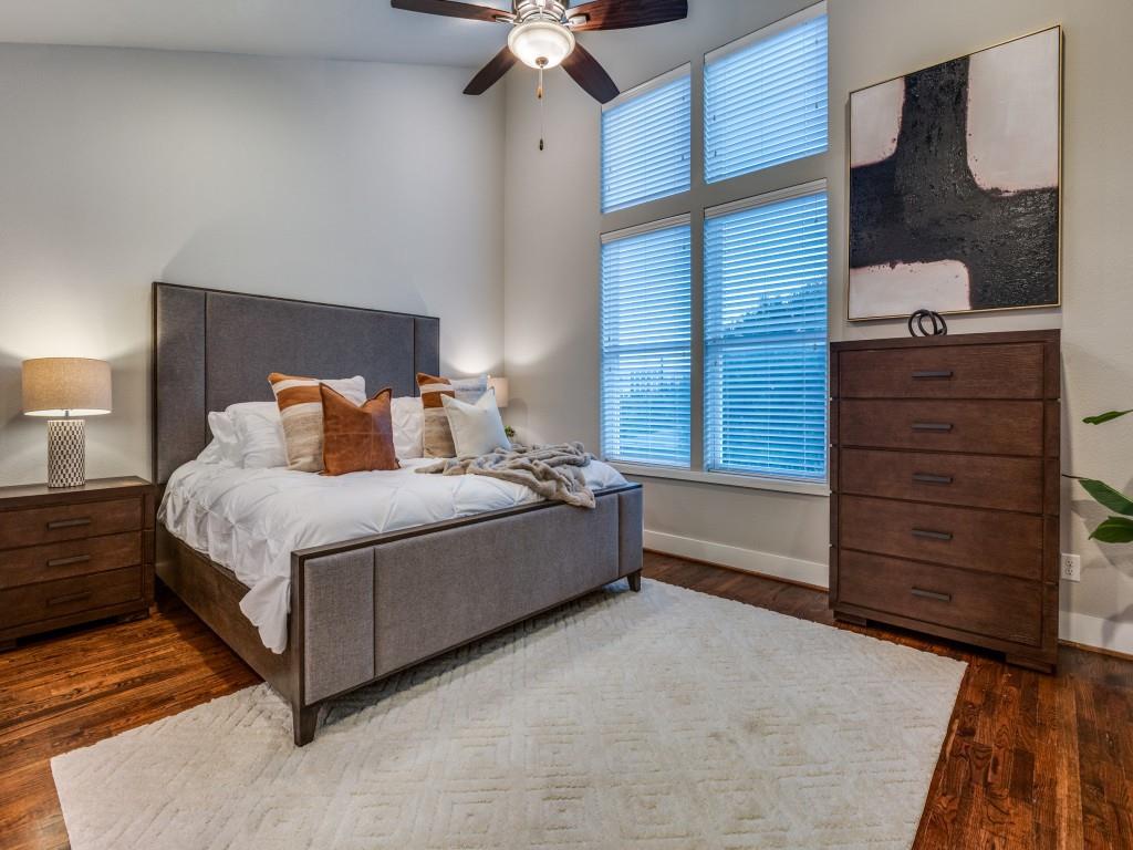 4211 Rawlins Street, Unit 97 Dallas, TX 75219 - Photo 12 of 24 a spacious bedroom with a bed and a ceiling fan