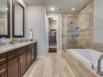 a bathroom with a granite countertop sink a mirror a bathtub and shower