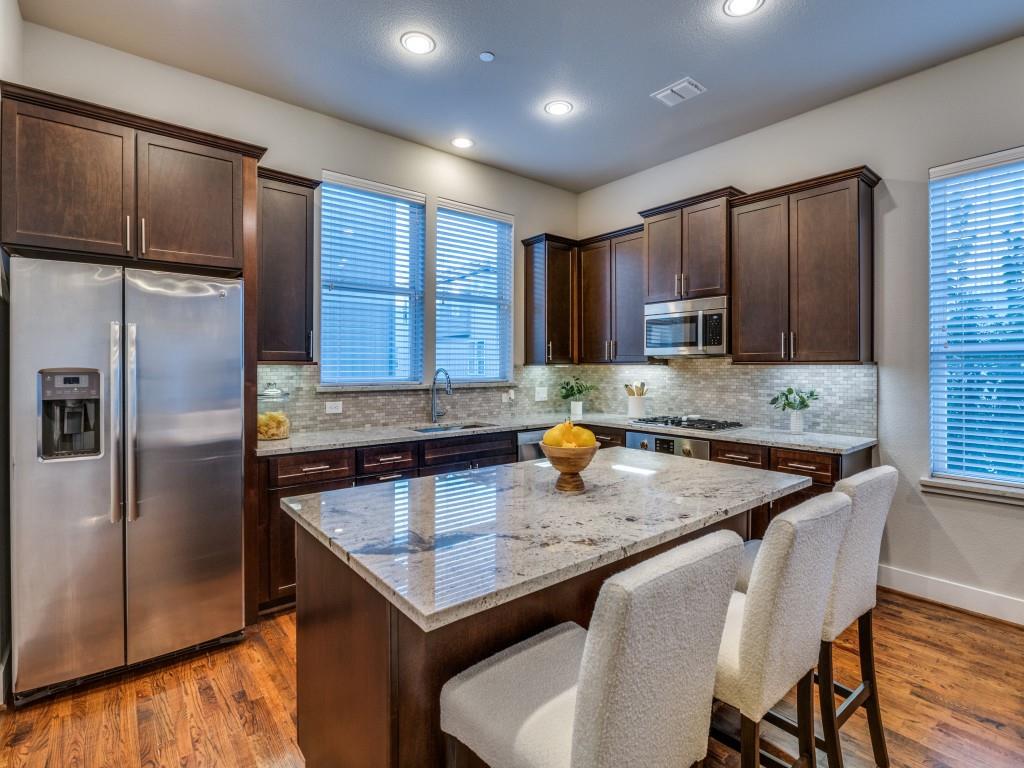 4211 Rawlins Street, Unit 97 Dallas, TX 75219 - Photo 6 of 24 a kitchen with stainless steel appliances granite countertop a sink refrigerator and microwave