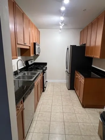 a kitchen with a refrigerator a stove top oven and cabinets