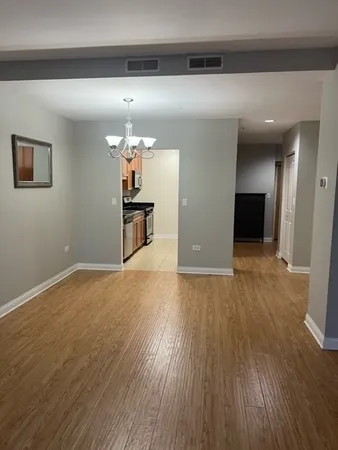 a view of a room with wooden floor and a ceiling fan