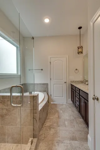 a spacious bathroom with a double vanity sink a mirror and a bathtub