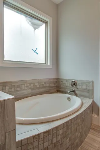 a bathroom with bathtub and window